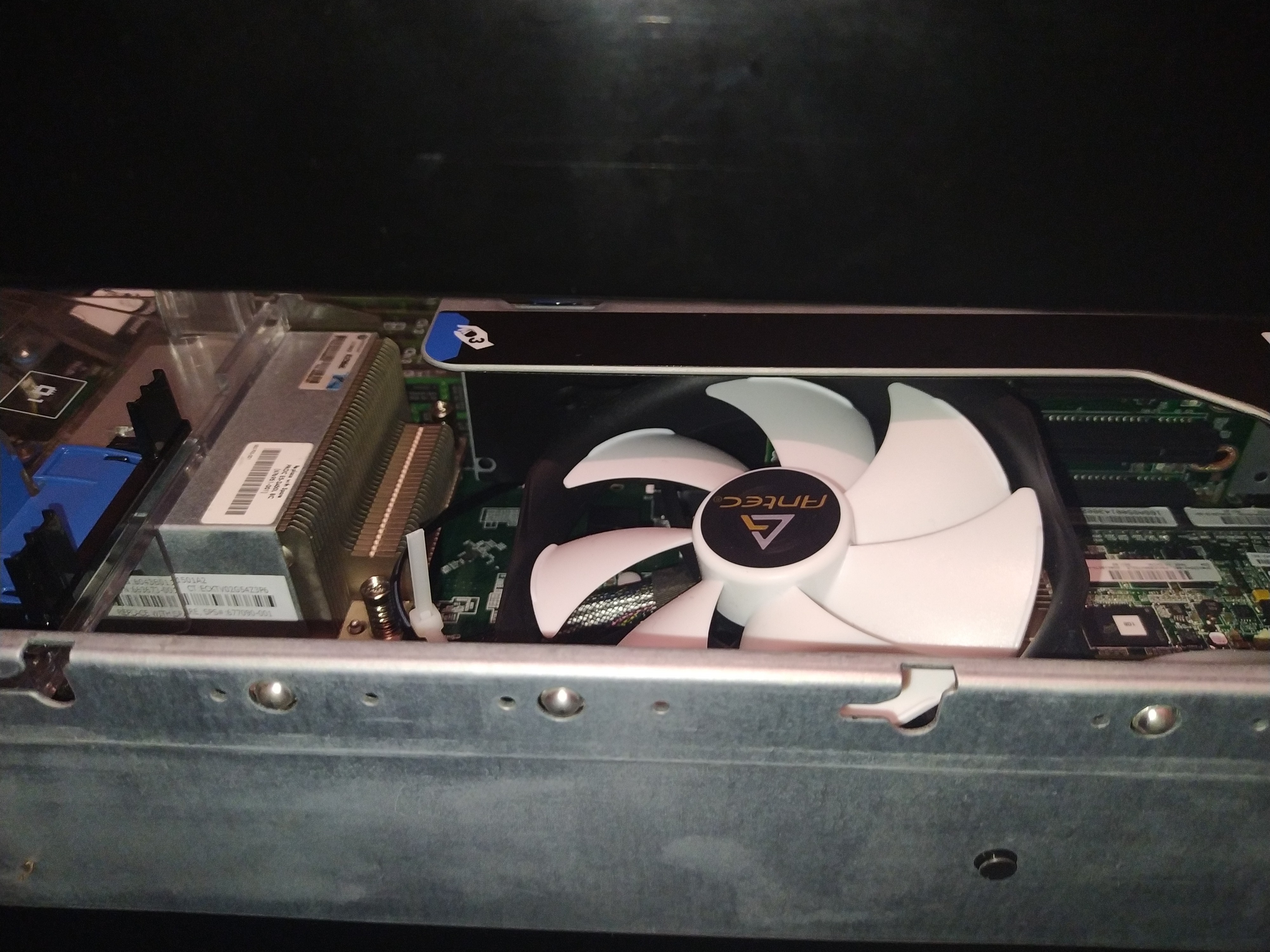 An image of a 120mm computer fan slotted into a rack mount HPE G8 server on top of a RAID card to improve temperatures and airflow.